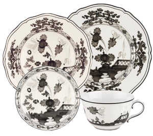 Four-piece Oriente Italiano Albus Dinnerware Collection by Ginori 1735 includes two plates, a saucer, and a teacup in black and white floral porcelain.