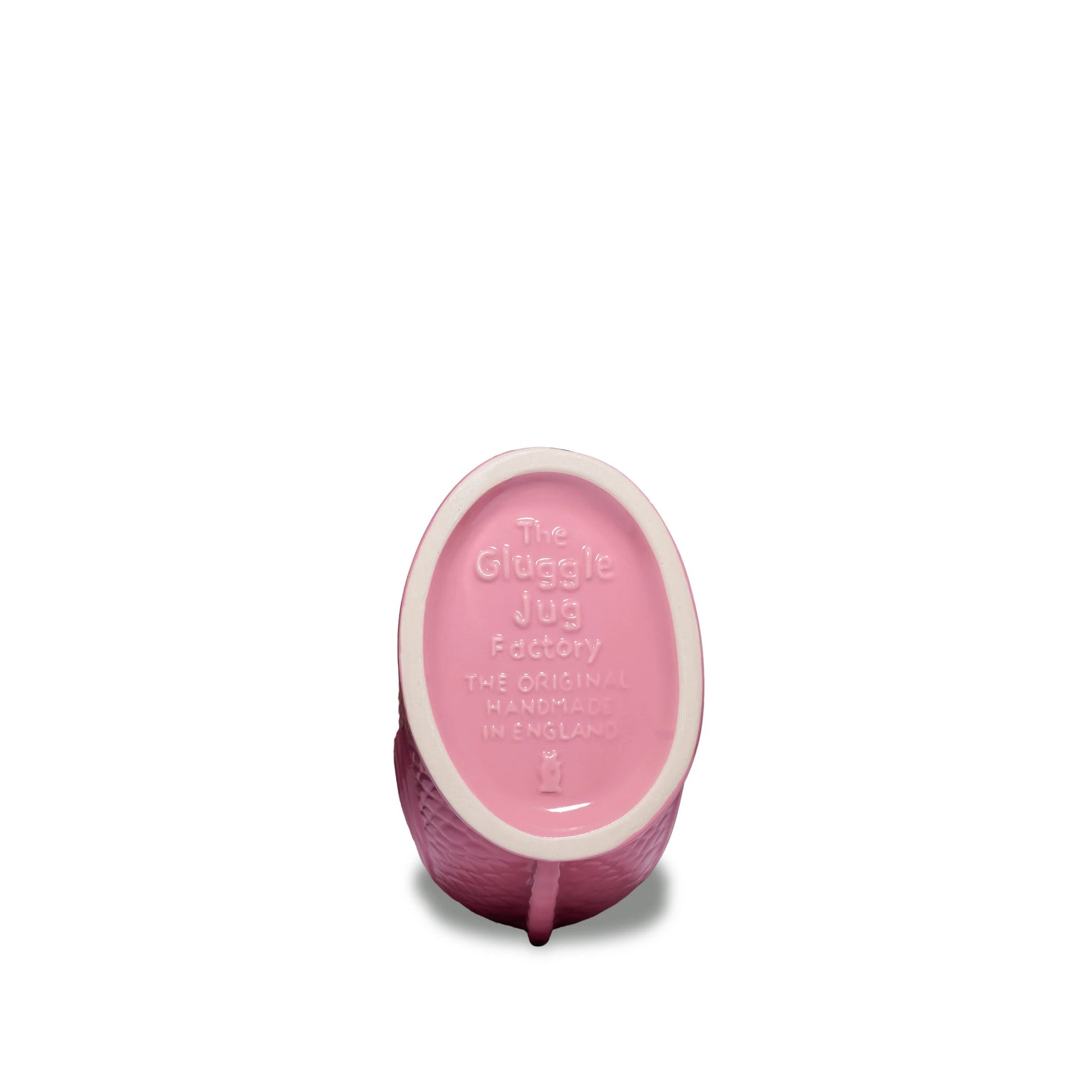 A pink ceramic jug from the Fish Gluggle Jug Collection by The Original Gluggle Jug, featuring embossed text: "The Gluggle Jug Factory The Original Handmade in England," celebrating this British design icon.