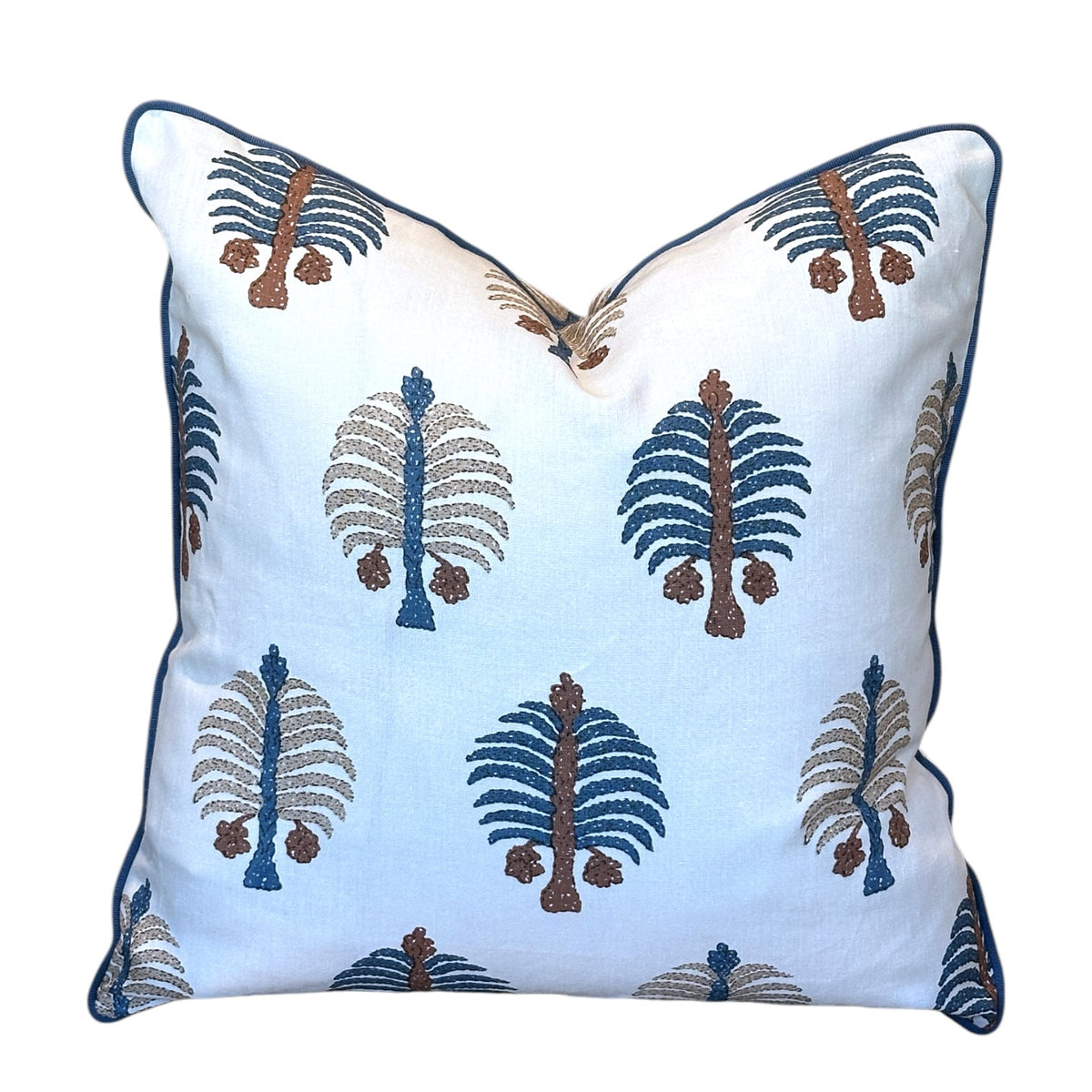 Introducing the Gobi Blue Down Pillow by Hive Custom Pillows—a 22x22 white square throw pillow adorned with blue, brown, and beige tree-inspired embroidered patterns and finished with elegant blue piping along the edges. Expertly handmade, this pillow can be custom crafted with a luxurious down fill for enhanced comfort and style.