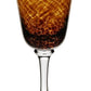 The Vanessa Tortoise Collection wine glass by William Yeoward Crystal features a textured amber and brown bowl, creating an optical illusion on its clear stem and base.