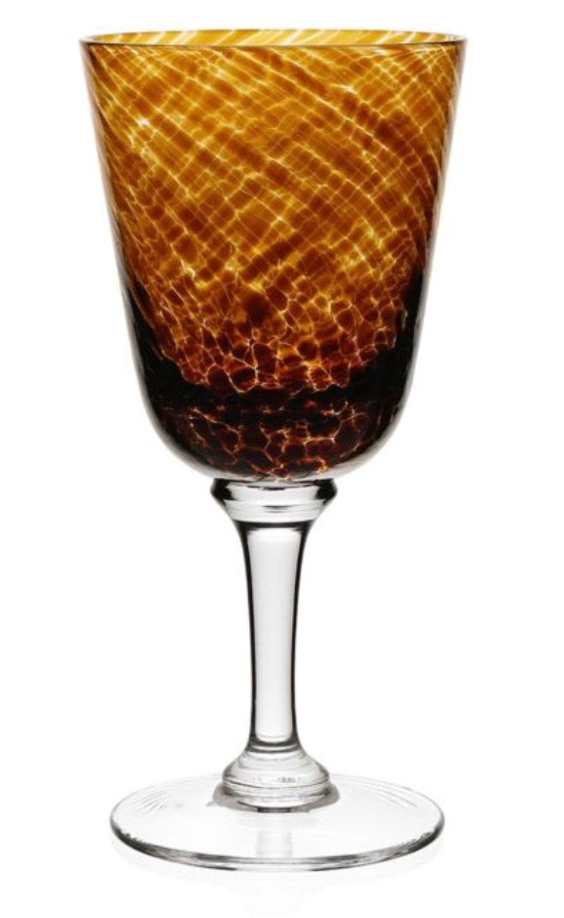 The Vanessa Tortoise Collection wine glass by William Yeoward Crystal features a textured amber and brown bowl, creating an optical illusion on its clear stem and base.