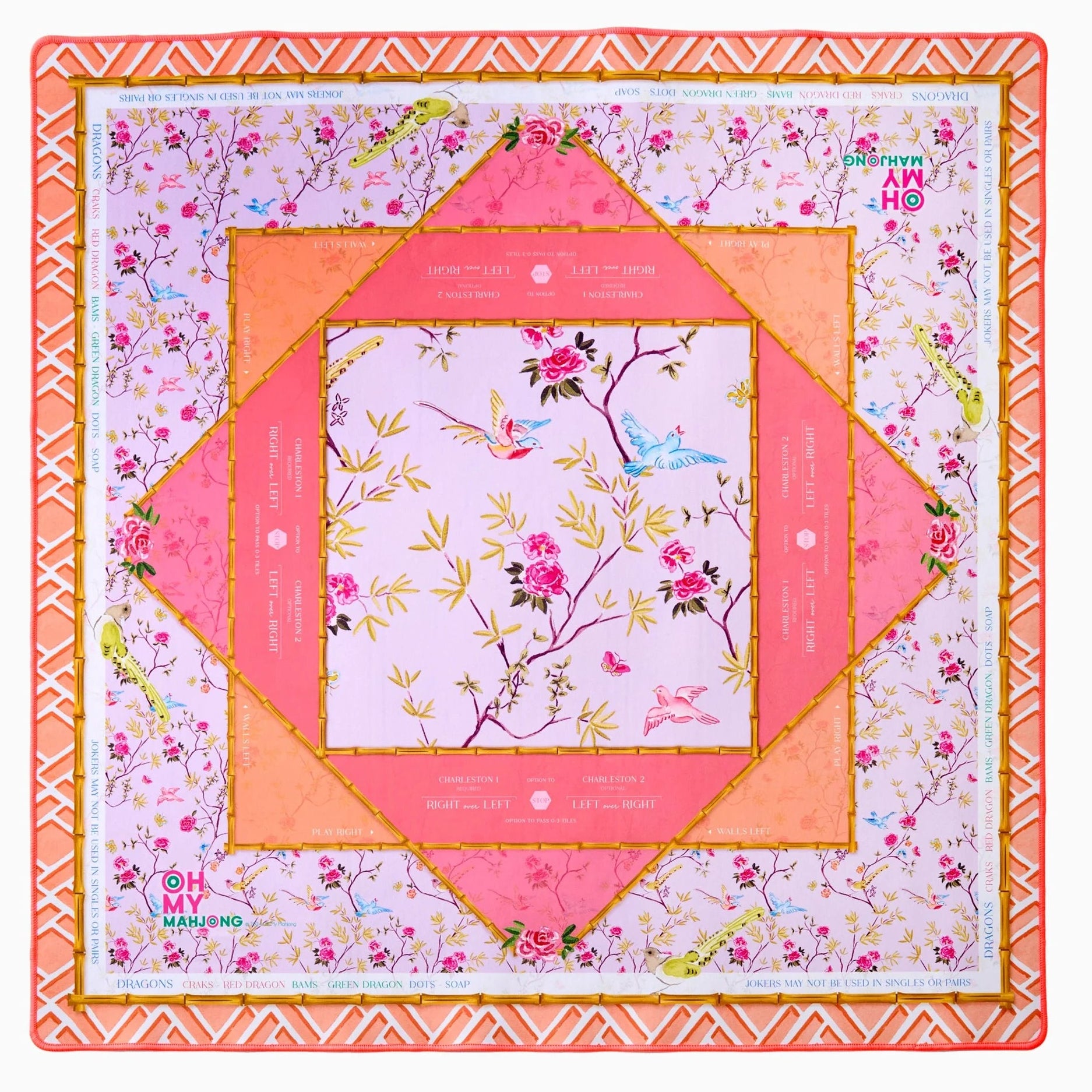 The Mahjong Mat Collection by Oh My Mahjong is a square, multi-layered mat with floral and geometric patterns in pink, orange, and gold, featuring measurement markings on the edges and a non-slip surface for stability.