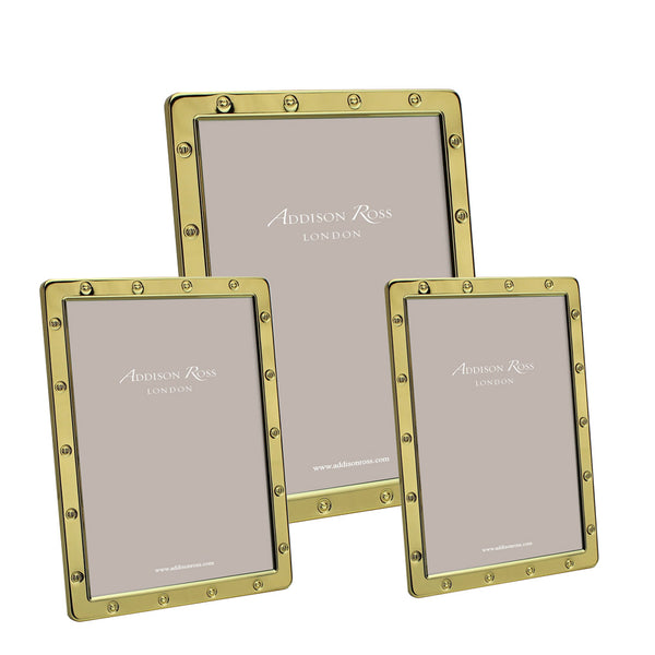 Three gold-plated frames from the Addison Ross Gold Locket Frame Collection are displayed in varying sizes. Each frame, boasting a studded border design, is showcased empty, revealing the Addison Ross brand's insert. These elegant frames also feature a luxurious velvet backstand and come thoughtfully gift boxed.