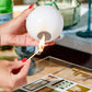 A person lights a match against the textured surface of a Golf Match Striker.
