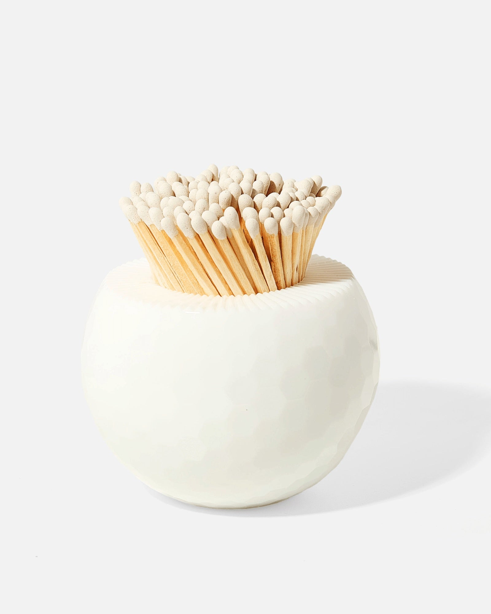 The Tart by Taylor Golf Match Striker Collection features a round white ceramic holder inspired by a golf ball, filled with wooden matches topped with white heads—an elegant accessory for match striking.