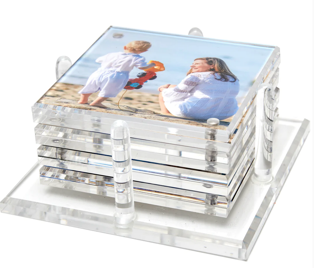 The Tara Wilson Designs Photo Drink Coaster Set features clear coasters displaying your favorite photo of a woman and child at the beach, neatly stacked in a matching acrylic holder to showcase cherished memories.