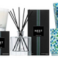 The Nest Forest Rain Scent Collection features a scented candle, reed diffuser, and decorative candle in black and patterned green-blue packaging, evoking an aquatic veil of fig leaves.