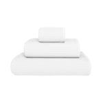 Three white towels of varying sizes from the Puro White Bath Collection by GRACCIOZA, featuring Zero Twist technology for natural comfort and high absorbency, neatly stacked against a plain white background.