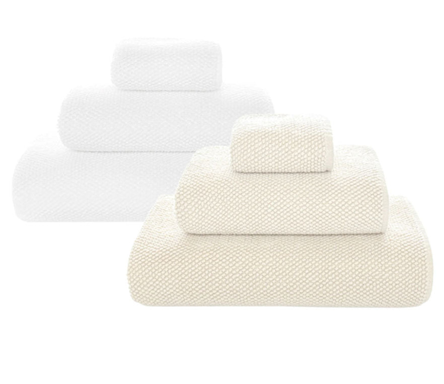 Two sets of ultra-soft, absorbent towels from the Graccioza Pearls Bath Collection—one in white, one in beige—are neatly stacked from largest to smallest on a plain white background.