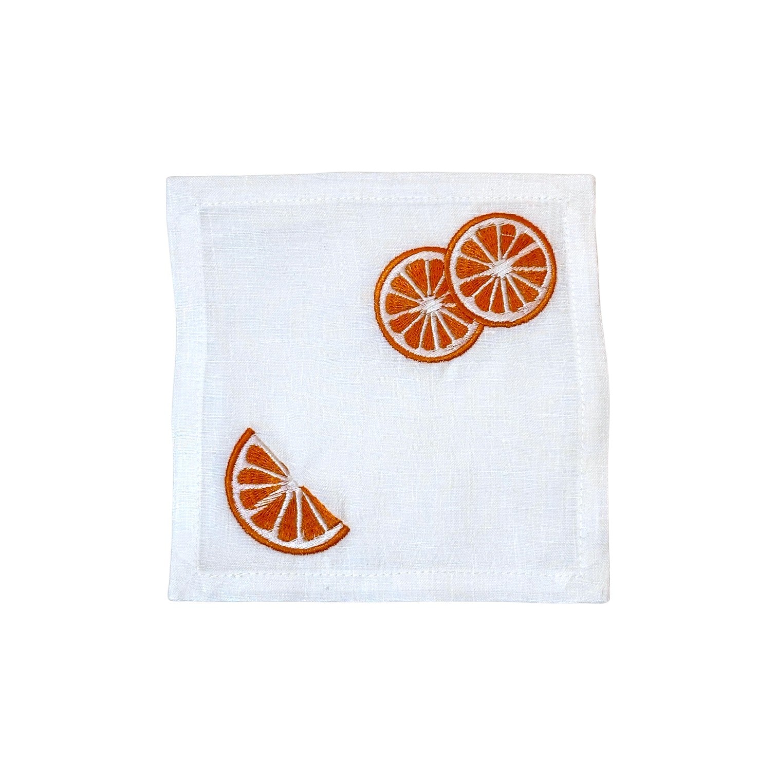 White linen napkin with embroidered orange slices—three whole in one corner, a wedge in the other—pairs perfectly with Haute Home's Grapefruit Coaster Set for a fresh, coordinated table.