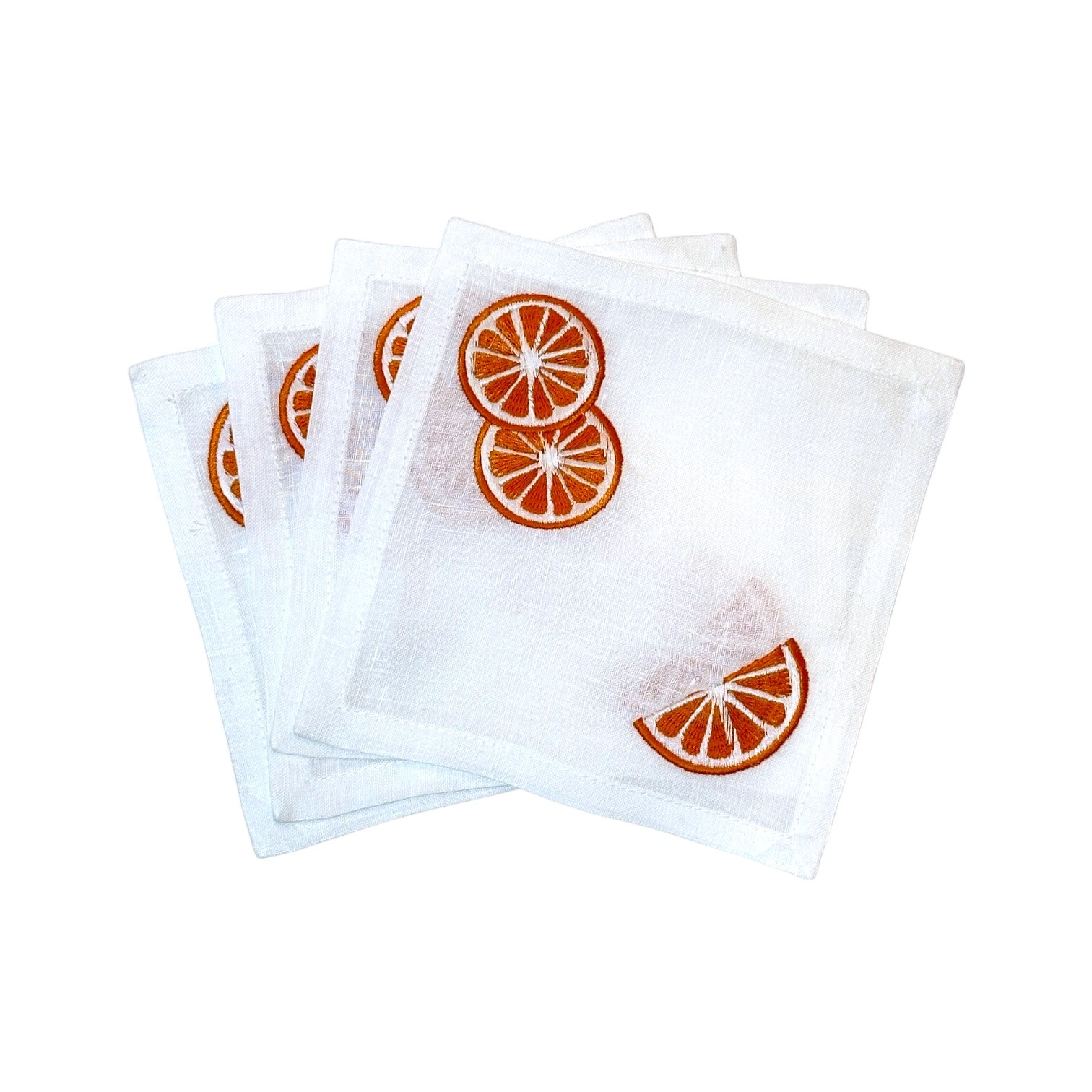 The Haute Home Grapefruit Coaster Set includes four white cloth napkins, each hand embroidered with a grapefruit slice in one corner—ideal for adding charm to any table setting.