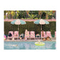 A scene reminiscent of Gray Malin's fine art is captured in the Gray Malin 500 Piece Puzzle, "The Dogs at the Beverly Hills Hotel" by Chronicle Books, showing dogs on pink chairs and under umbrellas by a pool with one dog swimming, against a hedge and tree backdrop.