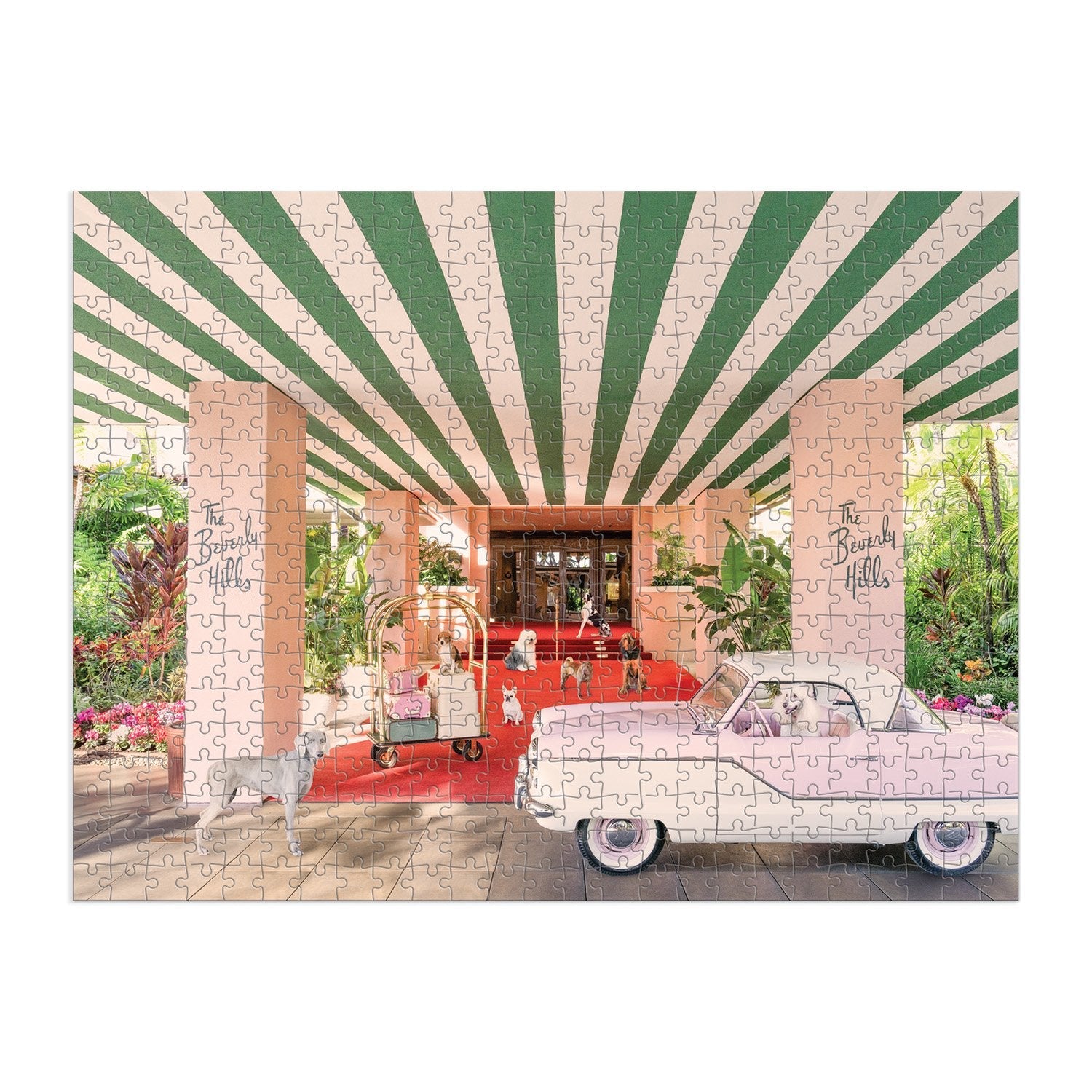 The Gray Malin 500 Piece Puzzle, The Dogs at the Beverly Hills Hotel by Chronicle Books, features a vintage pink car and luggage cart under a green and white striped canopy at a hotel entrance surrounded by lush tropical plants. It evokes the charm of fine art photography.