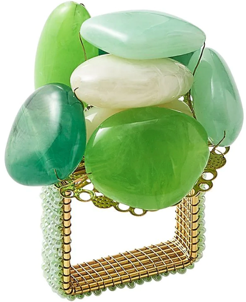 The Kim Seybert Sea Stone Napkin Ring features polished green beach stones stacked on a gold wire and a beaded rectangular frame for a decorative touch.
