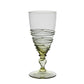 Part of the Ella Drinkware Collection by Juliska, this artisan glass goblet features a pale green tint, a spiral ribbed pattern around the bowl, and an elegant decorative stem. It is photographed on a white background.