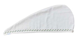 The Weezie Towels Hair Towel Wrap is a white microfiber wrap featuring a green zigzag edge stitch, a secure fastening button, and room for custom embroidery.