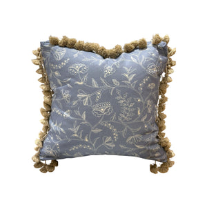 The Greta Alta Pillow by Hive Custom Pillows features light blue fabric, white floral embroidery, and tan pom-pom trim—a beautiful handmade decorative accent for a unique touch.