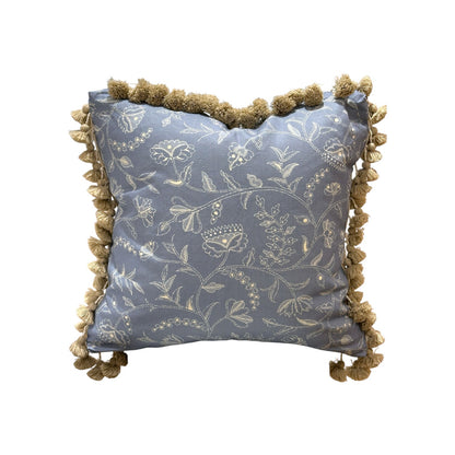 The Greta Alta Pillow by Hive Custom Pillows features light blue fabric, white floral embroidery, and tan pom-pom trim—a beautiful handmade decorative accent for a unique touch.