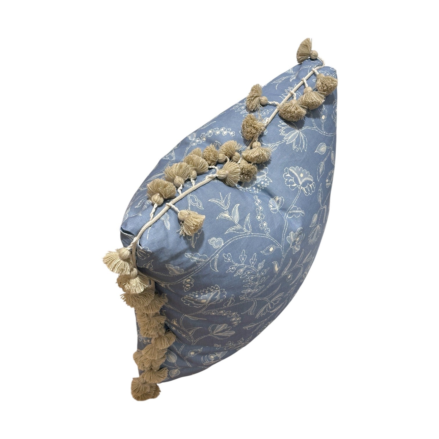 The Greta Alta Pillow by Hive Custom Pillows features blue fabric with white floral patterns and beige tassels along the edges. Shown on its side against a white background, this pillow is 100% down-filled for superior comfort.