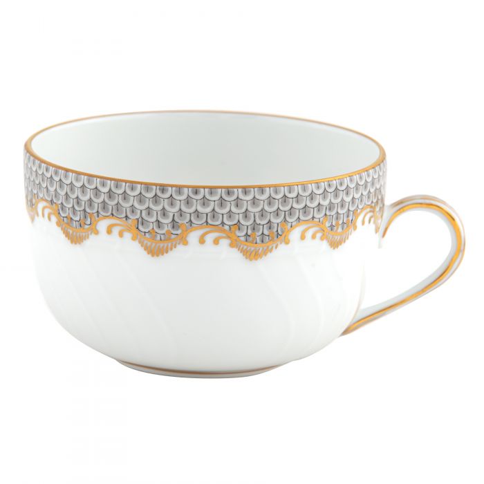 A white teacup from the Herend Fish Scale Gray Collection by Herend, featuring a delicate pattern of gray scales and gold accents along the rim and handle, reminiscent of Queen Victoria's refined taste in porcelain.