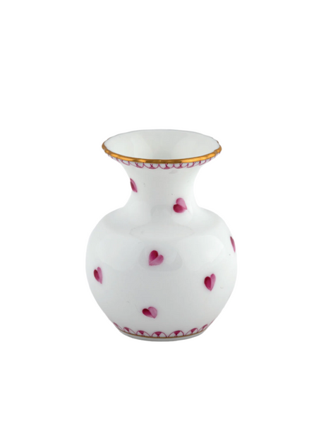 The Herend Small Heart Vase in Pink by Herend features a round white porcelain body, wide mouth, small pink heart accents, gold rim, and delicate hand-painted details on a plain white background.
