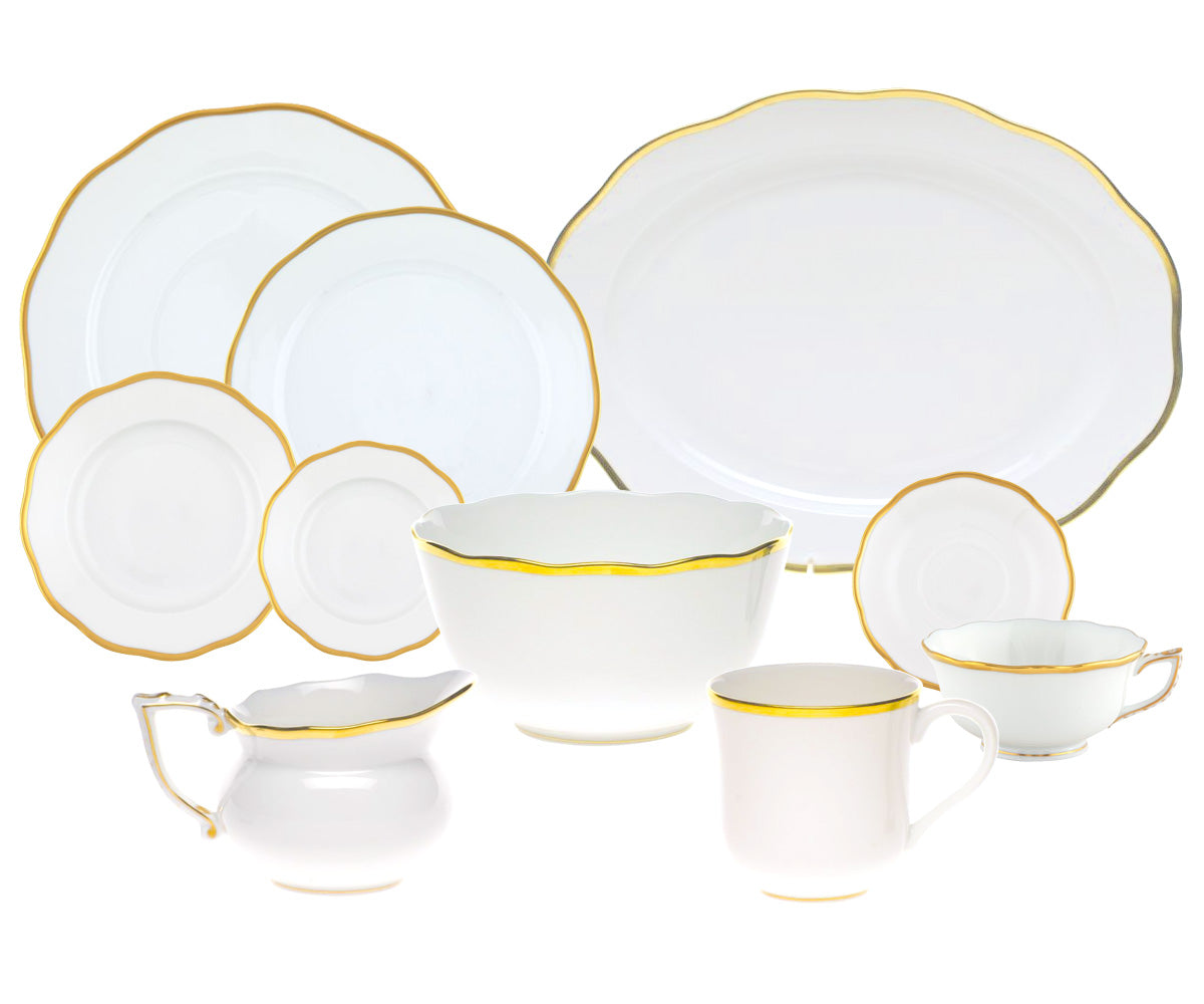 The Herend Gwendolyn White and Gold Collection features porcelain dishes, bowls, cups, and a creamer with scalloped edges and 24k gold trim, beautifully arranged on a white background.