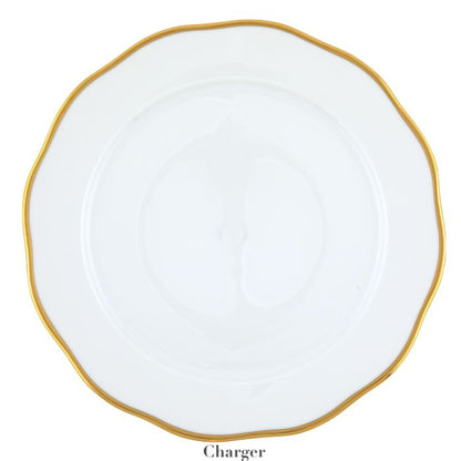 The Gwendolyn White and Gold Collection charger plate by Herend features a wavy rim, elegant white porcelain, and a 24k gold border—an ideal choice for those with refined artistic taste.