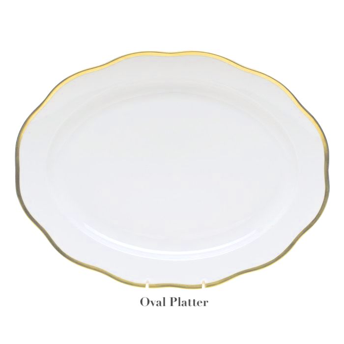 The Herend Gwendolyn White and Gold Collection oval porcelain platter features a scalloped edge and 24K gold trim, displayed on a stand with the label "Oval Platter" beneath it.