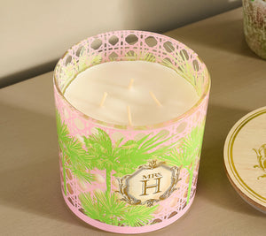 The Slatkin & Co. Mrs. H Candle features three wicks and a luxe pink and green holder with a gold "Mrs. H" label, filling your space with an elegant green tea fragrance.