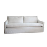 The Hannah Condo Sofa in Nit Witty Sea Salt by Verellen features two back cushions, a long seat cushion, straight arms, and a tailored skirt, creating an inviting focal point for any living room. Set against a white background, its clean lines and subtle elegance are beautifully highlighted by the Sea Salt finish.