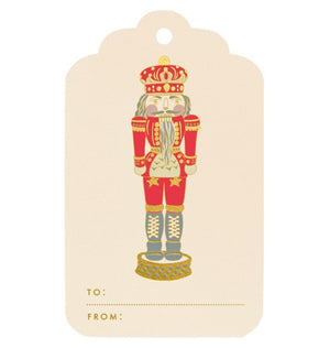 Crane’s Nutcracker Gift Tag Set features red and gold nutcracker soldier designs with “TO:” and “FROM:” spaces at the bottom for easy gifting.