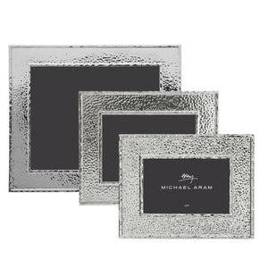 Three Michael Aram Hammertone Frames in varying rectangular sizes are stacked, each featuring a unique hammertone metal texture and distinctive black inserts branded with “Michael Aram.”.