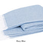 A folded light blue Pezzo Throw from Matouk, featuring white fringed edges and made from OEKO-TEX certified brushed cotton, labeled "Hazy Blue.