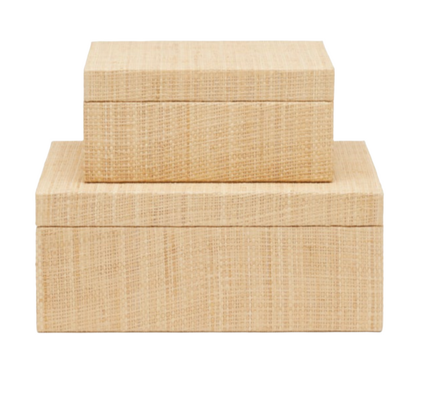 The Valeria Box, Small by Made Goods features two rectangular wooden boxes with natural woven raffia texture; the smaller box is casually stacked on top of the larger one against a white background, embodying casual beauty.