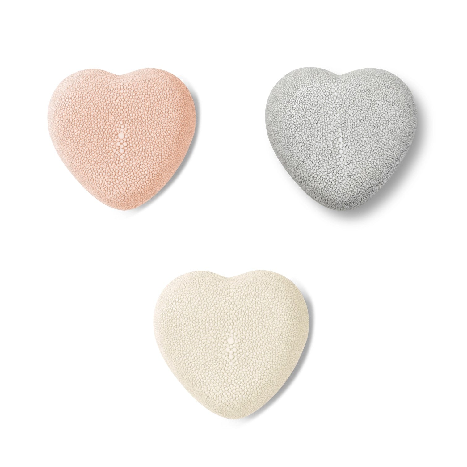 The Aerin Shagreen Heart Box Collection features three heart-shaped boxes in pink, gray, and off-white with embossed shagreen texture, beautifully arranged on a white background—ideal for displaying your jewelry keepsakes.