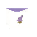 The Lilac Classic Card Set by Crane features a white engraved card with a purple lilac flower illustration, inspired by blooming bushes, and comes with a white envelope lined in lavender.