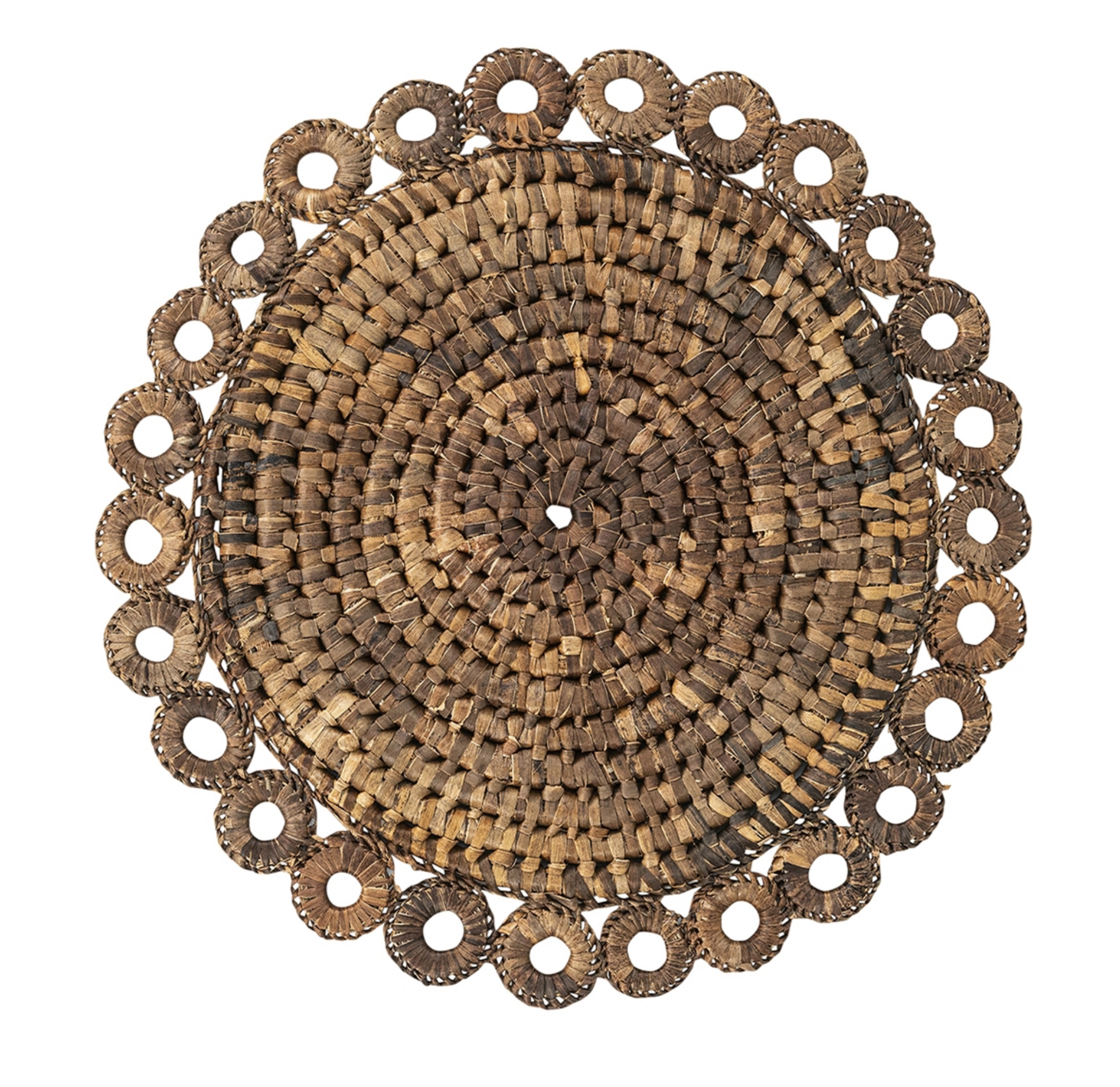 The Juliska Rustic Ring Placemat is a round, hand-woven placemat crafted from natural fibers, featuring a circular pattern with a decorative scalloped edge and central hole. Displayed on a white background, it’s the perfect rustic table decor for enhancing your natural table setting.