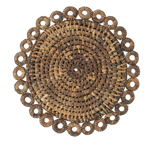 The Juliska Rustic Ring Placemat is a round, hand-woven placemat crafted from natural fibers, featuring a circular pattern with a decorative scalloped edge and central hole. Displayed on a white background, it’s the perfect rustic table decor for enhancing your natural table setting.