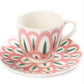 A handcrafted ceramic teacup and saucer from Themis Z's Symi Green and Pink Collection showcase a pink, white, and green floral design.