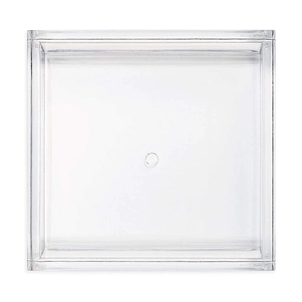 The Caspari Acrylic Luncheon Napkin Holder features a clear, square design with a central circular accent, adding modern elegance to your tabletop décor—shown from above on a white background.
