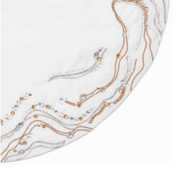 A white Kim Seybert Gilt Wave Tree Skirt featuring swirling lines of metallic gold and silver thread, accented with small clear beads and gold studs.