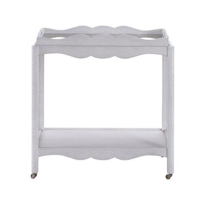 The Lawson Bar Cart by Branch Home features a white wooden frame with scalloped edges, a magnetic tray, an open bottom shelf, and four wheels—perfect for stylishly serving drinks or repurposing as needed.