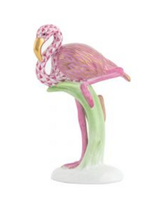 The Herend "Flamingo, Raspberry Pink" is a porcelain figurine featuring gold accents, hand-painted details, and stands elegantly on one leg atop a green and white base.