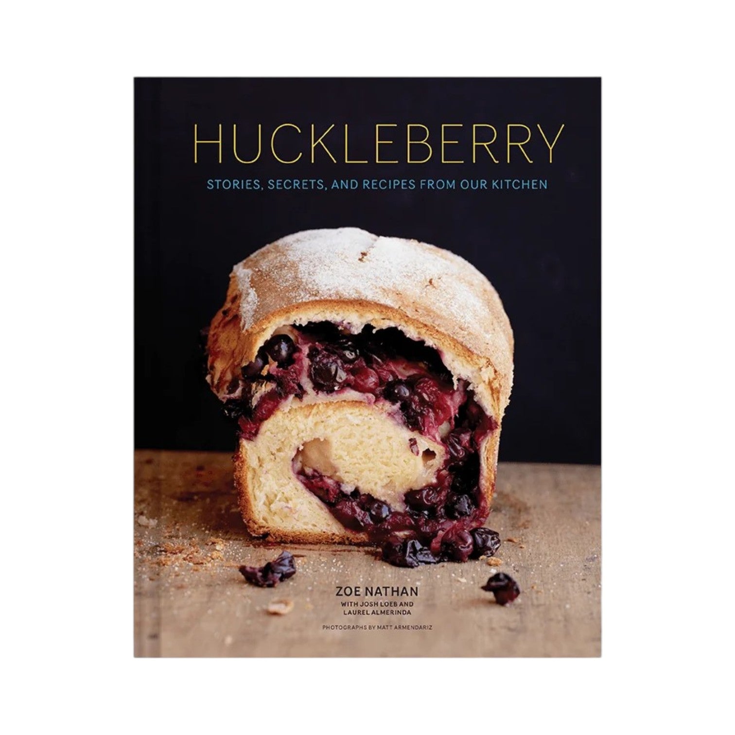 The cover of Huckleberry by Chronicle Books features a partially sliced loaf of berry-filled bread on a wooden surface—a charming preview of the bakery recipes and whole-grain baking inspiration inside.