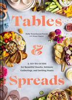 Cover of “Tables & Spreads” by Chronicle Books, displaying an artful arrangement of breads, dips, vegetables, fruits, and flowers on a table with the book’s title and subtitle in bold orange text—a comprehensive food styling guide and recipe collection for all occasions.