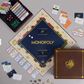 The WS Game Company Monopoly 90th Anniversary Edition features a dark blue and gold board, cards, play money, tokens, dice, and a wooden “90 Years” box—all displayed on a light surface.