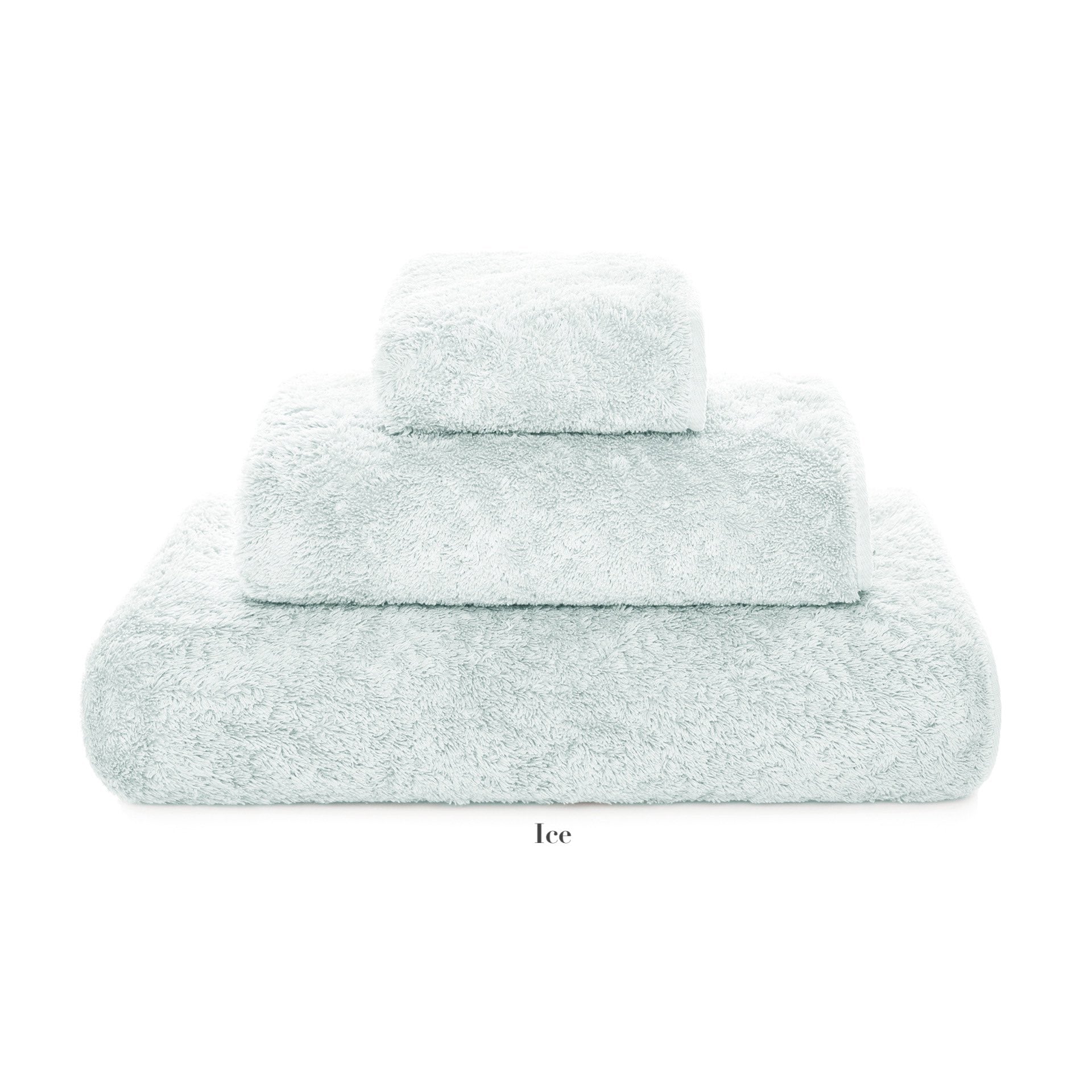 Three neatly stacked pale blue towels of different sizes from the Egoist Bath Collection by Graccioza, crafted from high density Egyptian cotton, displayed on a white background.