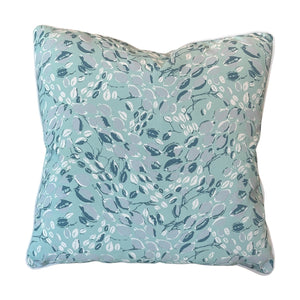 The Cowrie Shell Aqua Outdoor Pillow by Associated Design features an abstract leaf pattern in blue, white, and gray on a light blue background, crafted from premium materials for outstanding comfort.