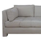 The Barrett Sofa in Ticking Stripe Dove by Highland House features gray and white ticking stripe upholstery, tufted seat cushions, and a matching rectangular pillow for a coastal-inspired look, displayed here from an angled side view.