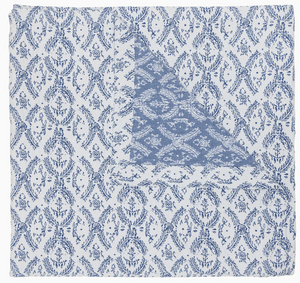 Part of the John Robshaw Aashna Azure Bedding Collection, this square cotton jacquard napkin displays a blue floral and vine motif on white, folded to reveal a contrasting blue design inspired by Portuguese tilework.